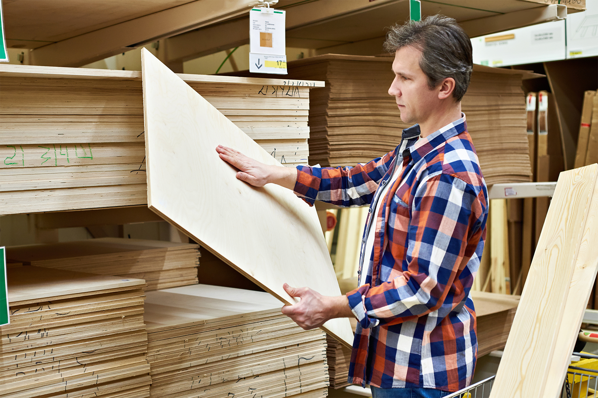 a man choosing a type of plywood by thickness