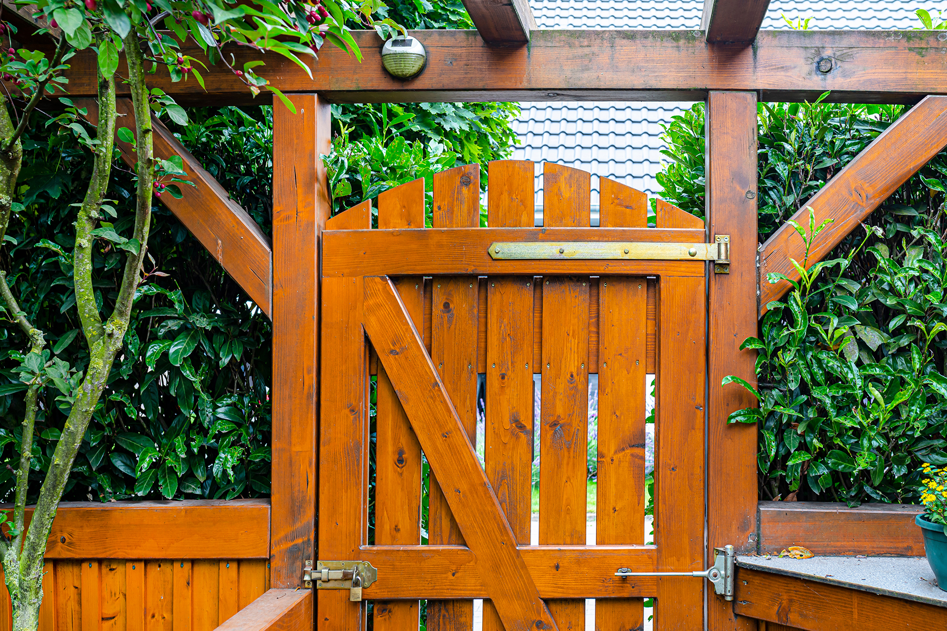 a garden gate and arch on a wooden fence