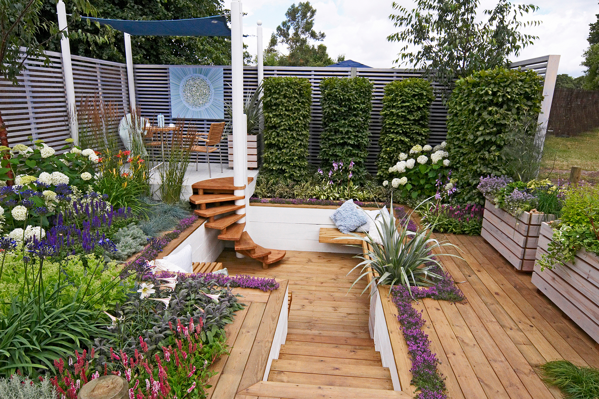 a sunken seating area surrounded by decking and raised beds